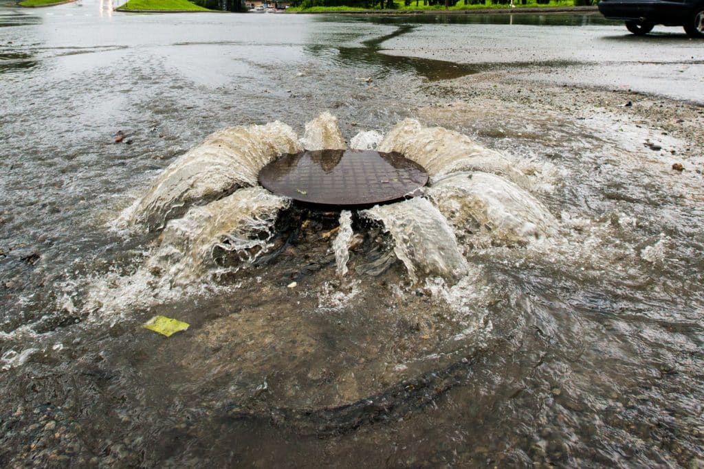 City sewer backup - water flowing over the road from a city's sewer system.