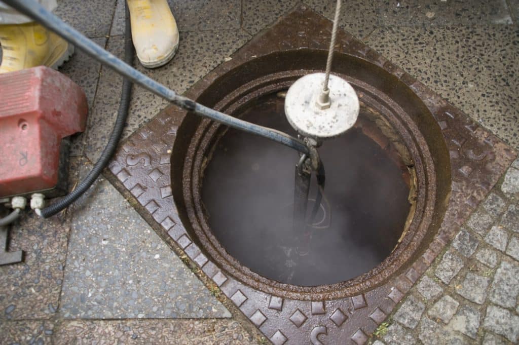 Professional plumbers cleaning a sewer system to avoid problems.