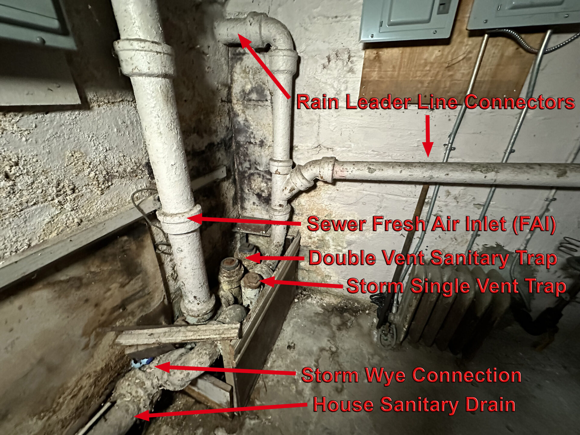 House drain traps and house drain plumbing inside a basement.