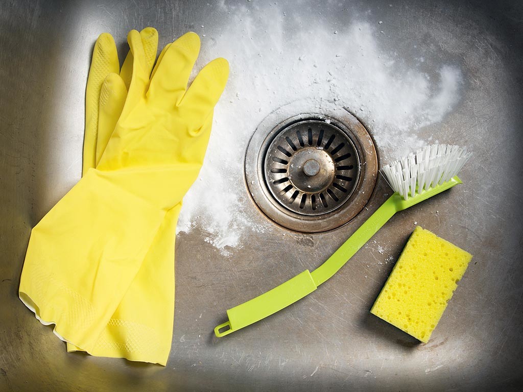 A kitchen sink with rubber gloves.