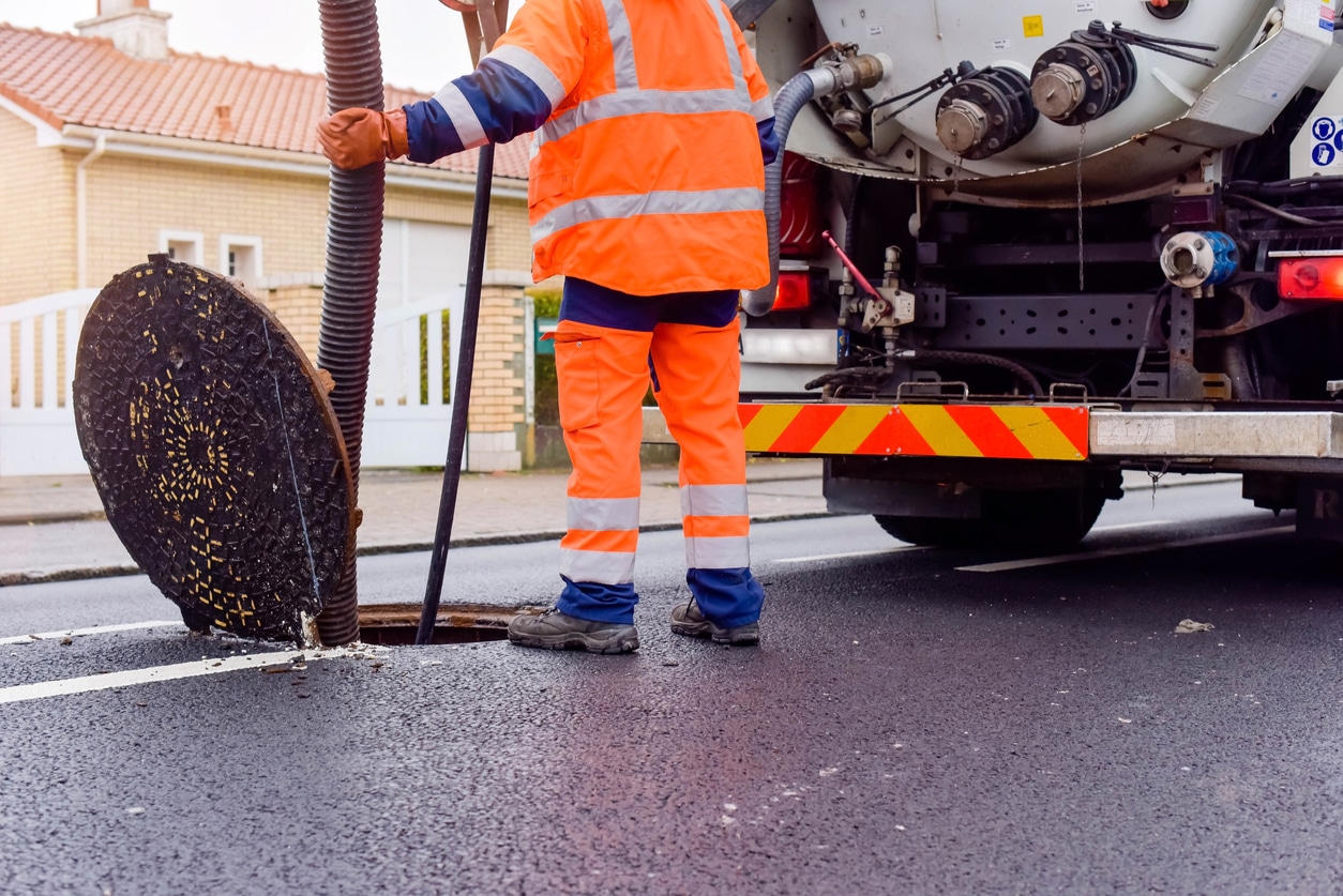 Workers performing residential sewer cleaning services using specialized tools.